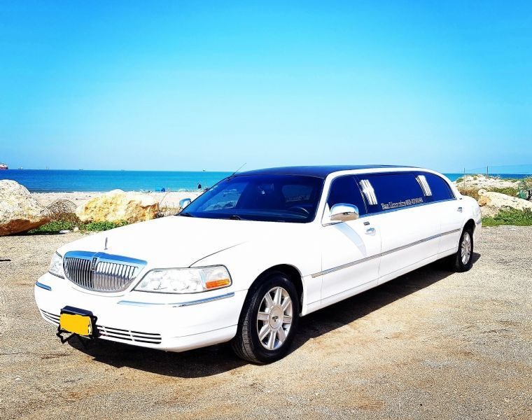 מכוניות וסירה להשכרה- לימוזינה לבנה ונוף לים